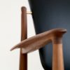 France Chair FJ 1360 walnut – black leather – armrest front detail